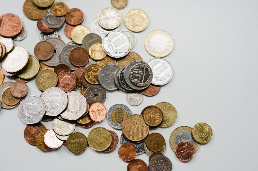A collection of various international coins spread on a soft white background.
